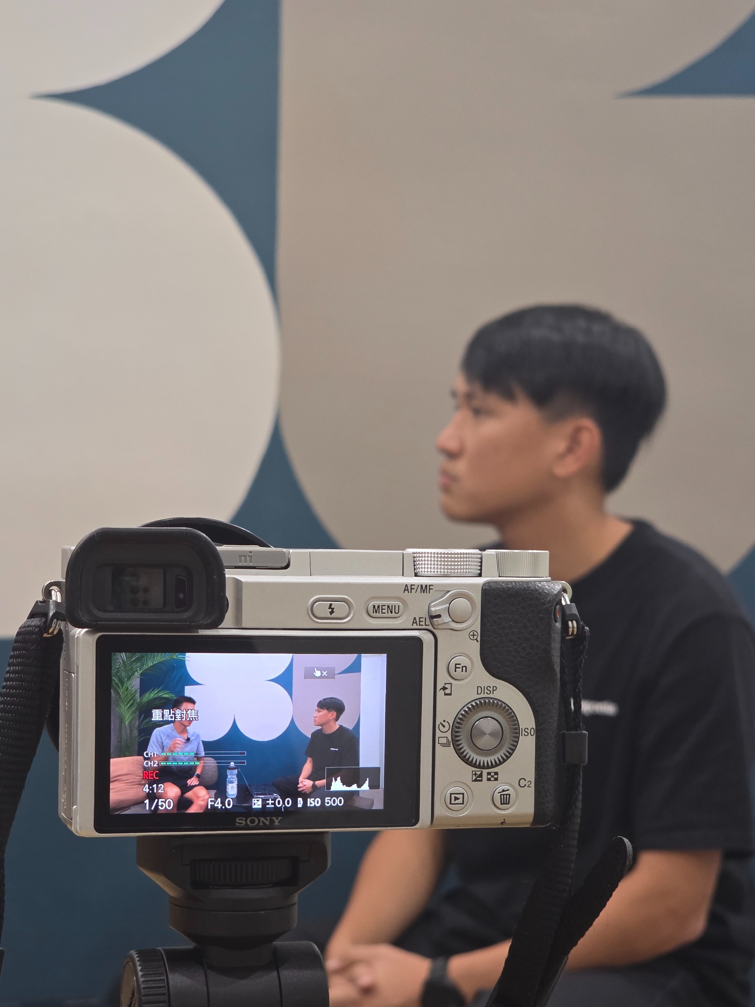 攝影機螢幕中呈現兩人坐著進行訪談